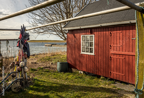 a red fisherman´s hut with fishing equipment on a danish shore photo