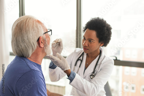 Doctor examine patient throat with spatula