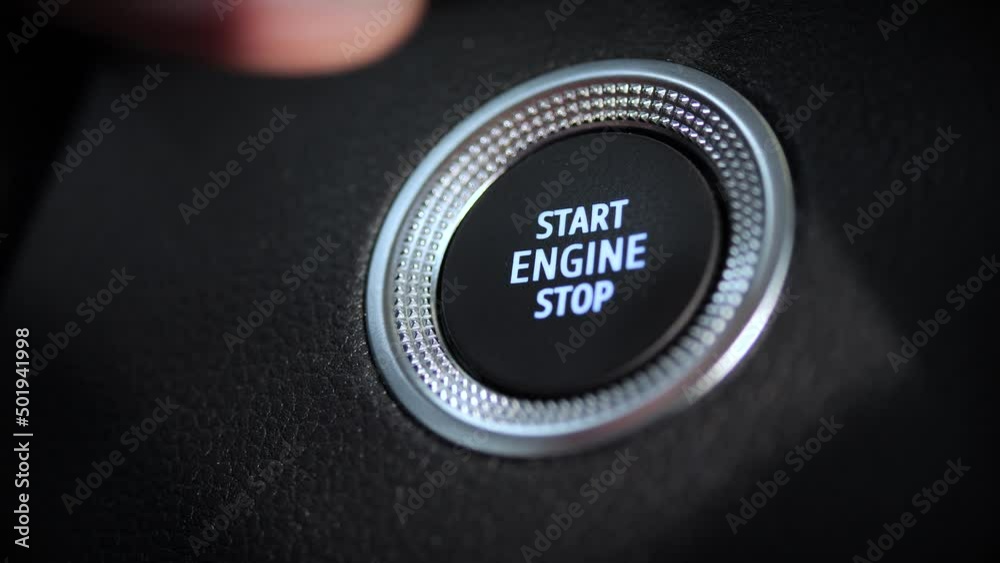 Un doigt appuie sur le bouton pour démarrer et couper le moteur d'une voiture
