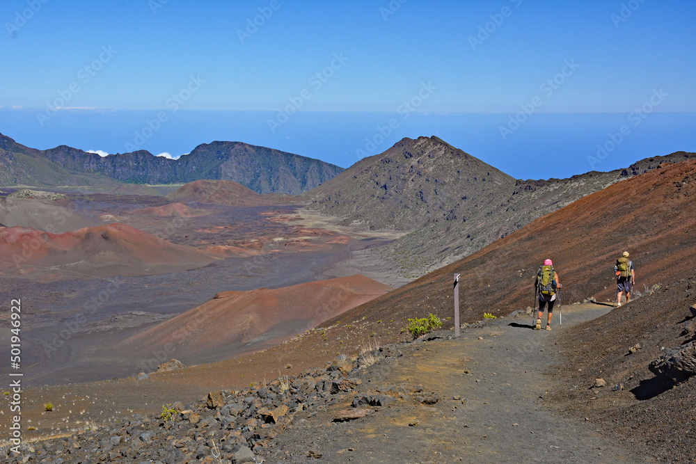 Summit view with hikers on a trail leading into the sacred Haleakala Crater on Maui island, Hawaii a U..S. National Park