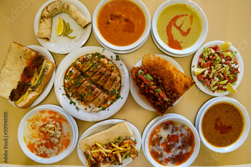 Traditional Turkish cuisine. Pizza, pita, pidesi, sucuk, hummus, kebab. Many dishes on the table. Serving dishes in restaurant. Background image. Top view, flat lay