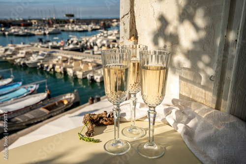 Three glasses of French champagne sparkling wine and view on colorful fisherman s boats in old harbour in Cassis  Provence  France