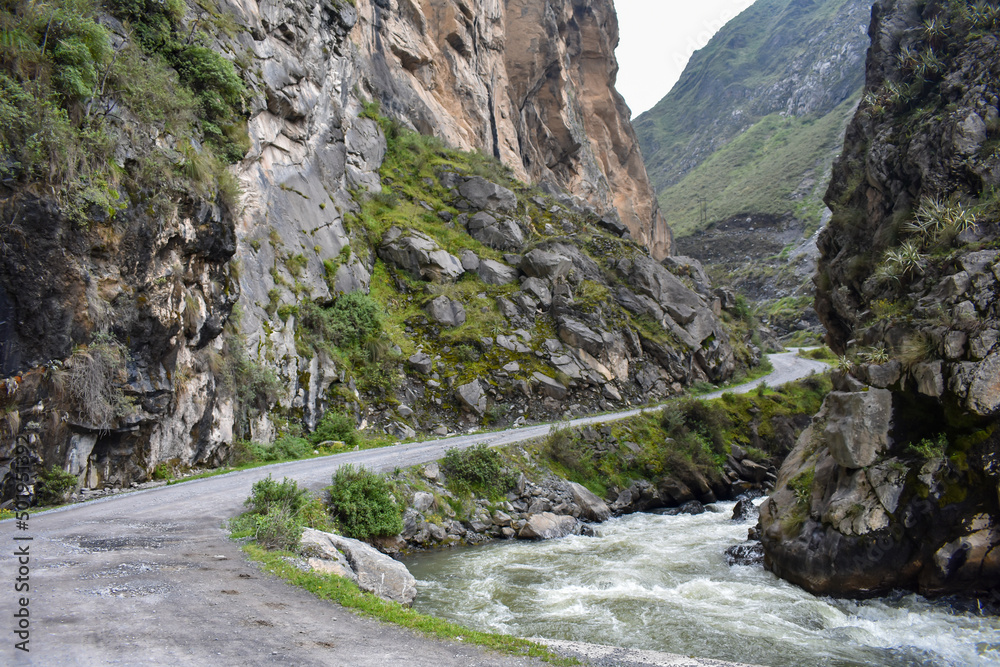 Rugged road in the middle of a canyon with a mighty river.
