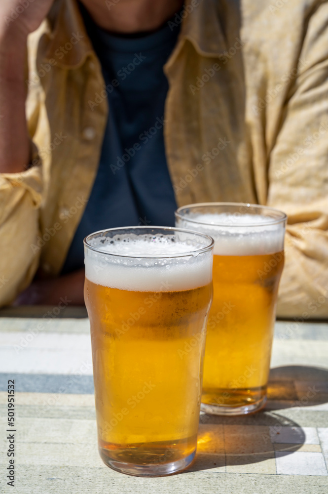 Men with two glasses of fresh cold lager beer in French outdoor cafe Men with two glasses of fresh cold lager beer in French outdoor cafe