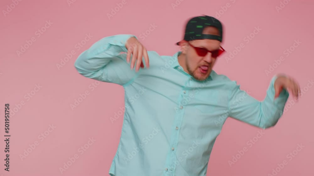 Funny joyful sincere man in sunglasses and marihuana cap making playful silly facial expressions and grimacing, fooling around showing tongue. Young handsome guy isolated alone on pink wall background Funny joyful sincere man in sunglasses and marihuana cap making playful silly facial expressions and grimacing, fooling around showing tongue. Young handsome guy isolated alone on pink wall background