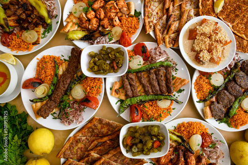 Fototapeta Naklejka Na Ścianę i Meble -  Delicious meat kebab with fresh vegetable salad served with variety of Turkish dishes and appetizers. Top view of assorted Turkish food and meze, tasty and healthy Mediterranean cuisine.