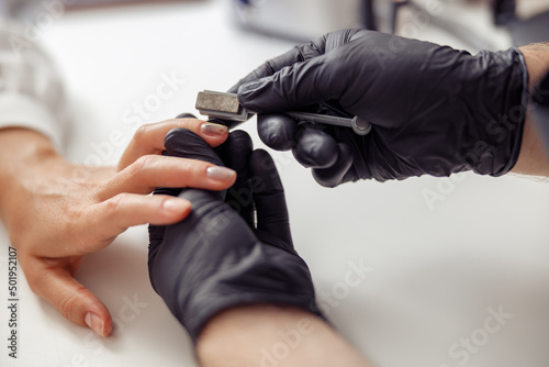 Modern woman during nail care service in salon