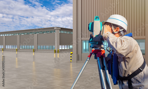 Surveyor next to industrial...