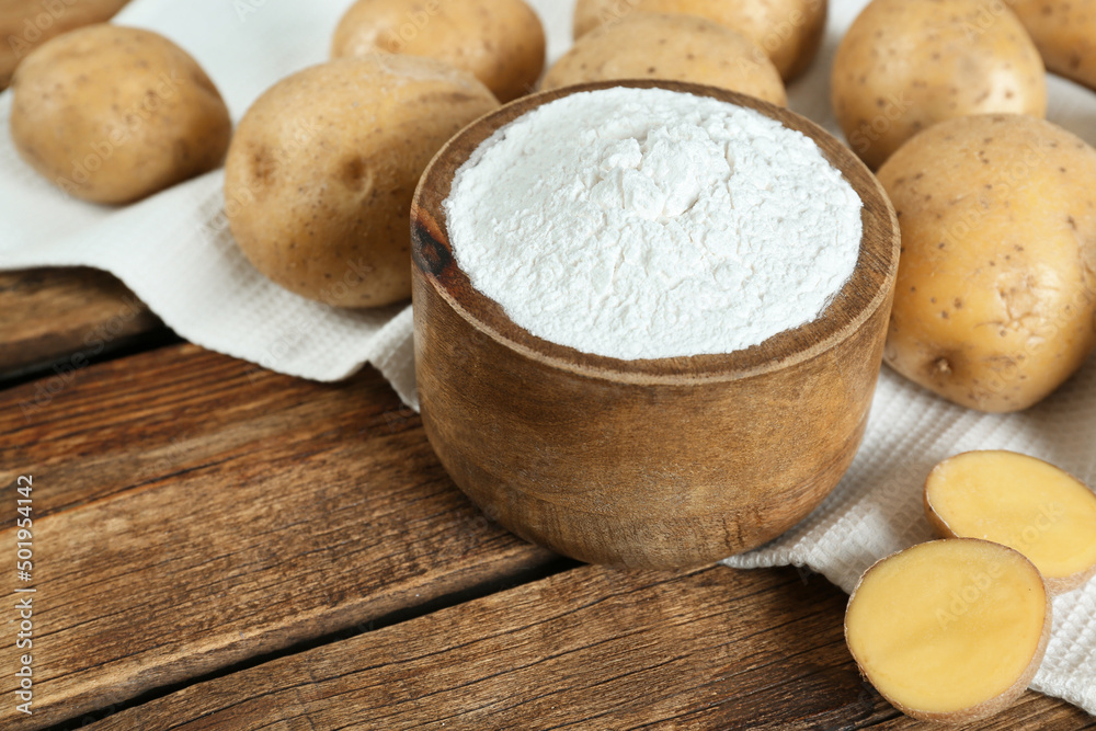 Starch and fresh raw potatoes on wooden table Starch and fresh raw potatoes on wooden table