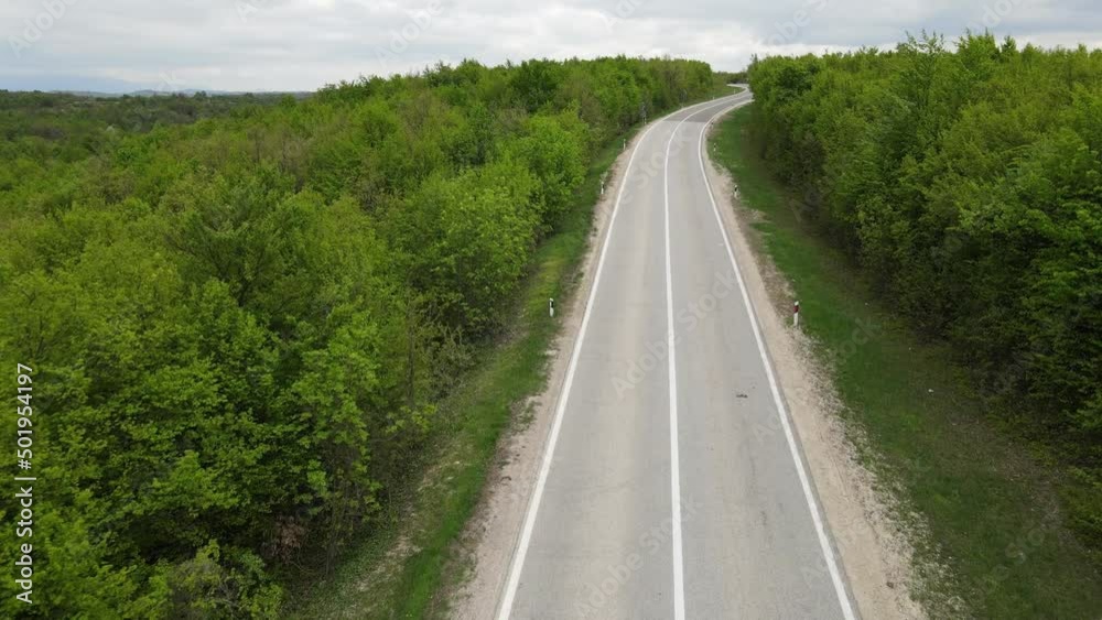 Top view on the road with cars travel and tourism transportation concept in spring day in trough the forest and trees aerial view from drone on Tresibaba - near Knjazevac Serbia Top view on the road with cars travel and tourism transportation concept in spring day in trough the forest and trees aerial view from drone on Tresibaba - near Knjazevac Serbia