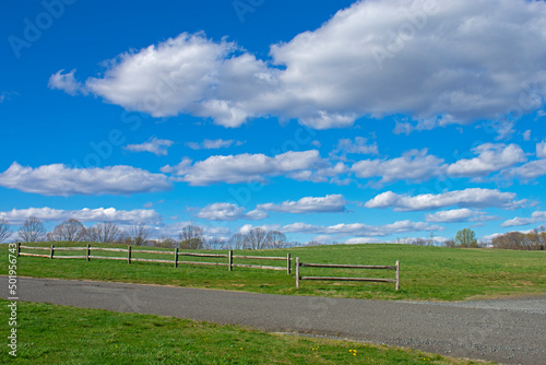 A sunny spring day with beautiful cumulus clouds over a fenced field at Big Brook Park, Marlboro, New Jersey -05