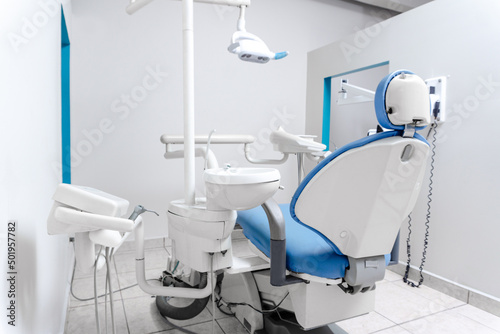 Modern Dental Clinic, Dentist chair and other accessories used by dentists in blue medical light.