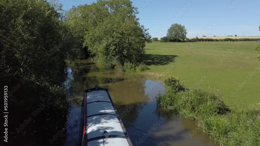A narrowboat passing underneath on the Oxford Canal. Rural scene A narrowboat passing underneath on the Oxford Canal. Rural scene