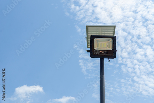 Close up street or garden lamp post with solar cell panel energy (against blue sky background)