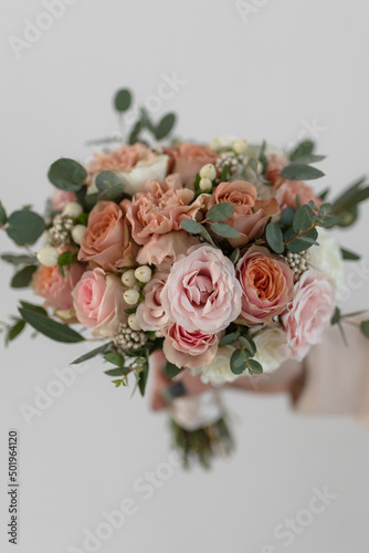 Wedding bouquet of the bride in delicate peach, beige and pink colors