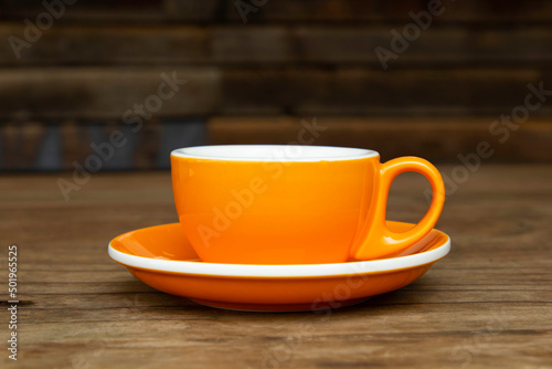 An orange coffee cup on a table