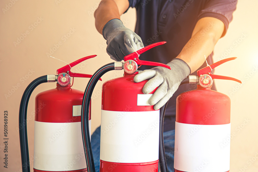 Naklejka premium Close up fire extinguisher and firefighter checking pressure gauge level for protection and prevent and safety rescue and use of equipment on fire training concept.
