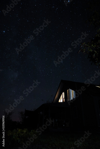 Country house under stary sky at night