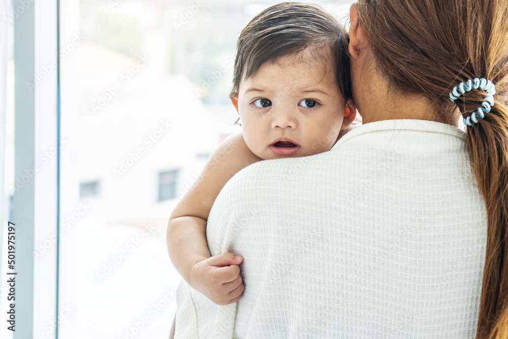 Loving mother holding and kisses the baby daughter, A young mother hugs and kisses her newborn daughter in the home Loving mother holding and kisses the baby daughter, A young mother hugs and kisses her newborn daughter in the home