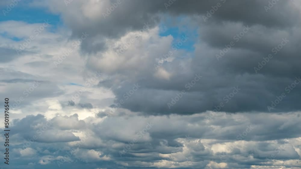 Time lapse footage of fast moving white puffy cumulus clouds on blue clear sky