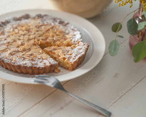 Bild auf Leinwand Homemade almond tart on a white plate with folk and knife.