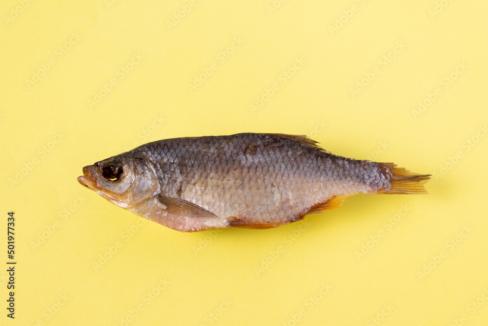 dried fish - rudd on a yellow background, isolate