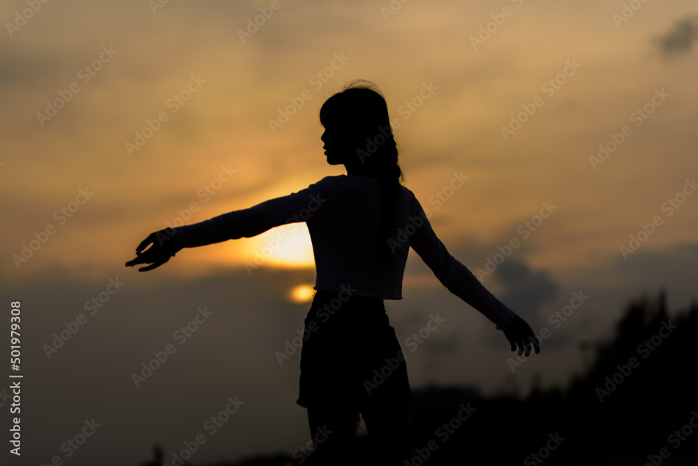 Silhouette of a happy woman on the beach.