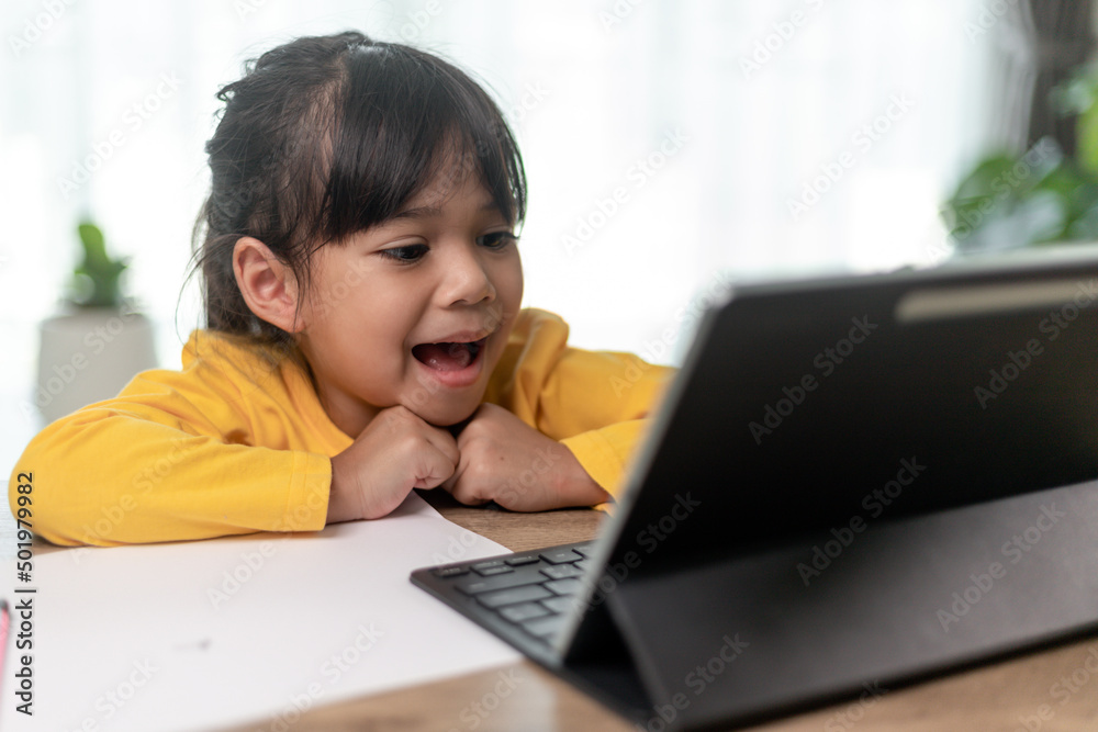 Asian little girl taking class on line and happy for Homeschool Quarantine coranavirus pandemic concept Asian little girl taking class on line and happy for Homeschool Quarantine coranavirus pandemic concept