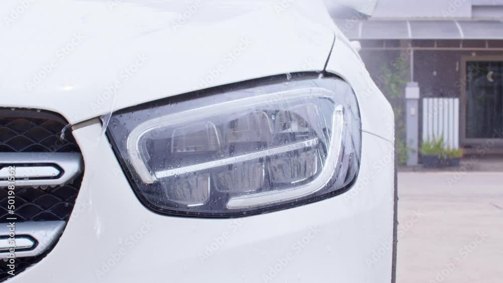 Close up water high pressure for cleaning and washing car.Water mist spraying to the white car for clean dust and stains.Car wash and detailing concept Close up water high pressure for cleaning and washing car.Water mist spraying to the white car for clean dust and stains.Car wash and detailing concept