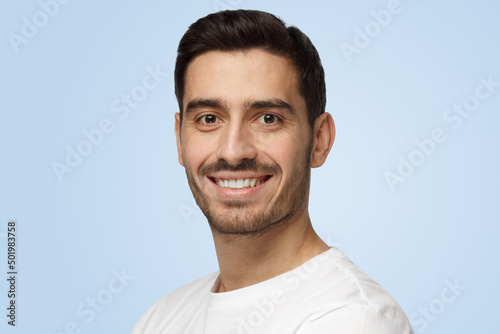 Attractive bearded man smiles to camera having pleased expression and cheerful look