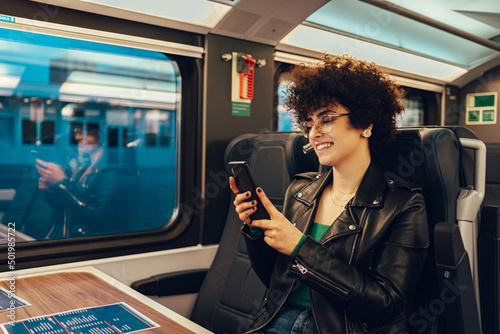 Woman tourist traveling by the train and using smartphone