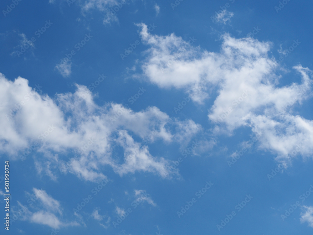 The natural background of the sky. Delicate white clouds on a transparent blue sky on a sunny day The natural background of the sky. Delicate white clouds on a transparent blue sky on a sunny day