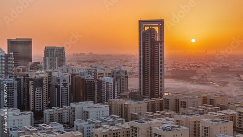 Sunrise over skyscrapers in Barsha Heights district and low rise buildings in Greens district aerial timelapse.