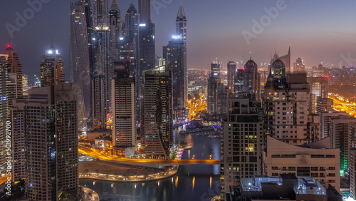 Fototapeta Naklejka Na Ścianę i Meble -  View of various skyscrapers in tallest recidential block in Dubai Marina aerial night to day timelapse