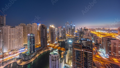Panorama of various skyscrapers in tallest recidential block in Dubai Marina aerial night to day timelapse