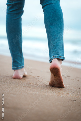 Closeup of a mans bare feet walking at a beach. © Fotografia Juan Reig