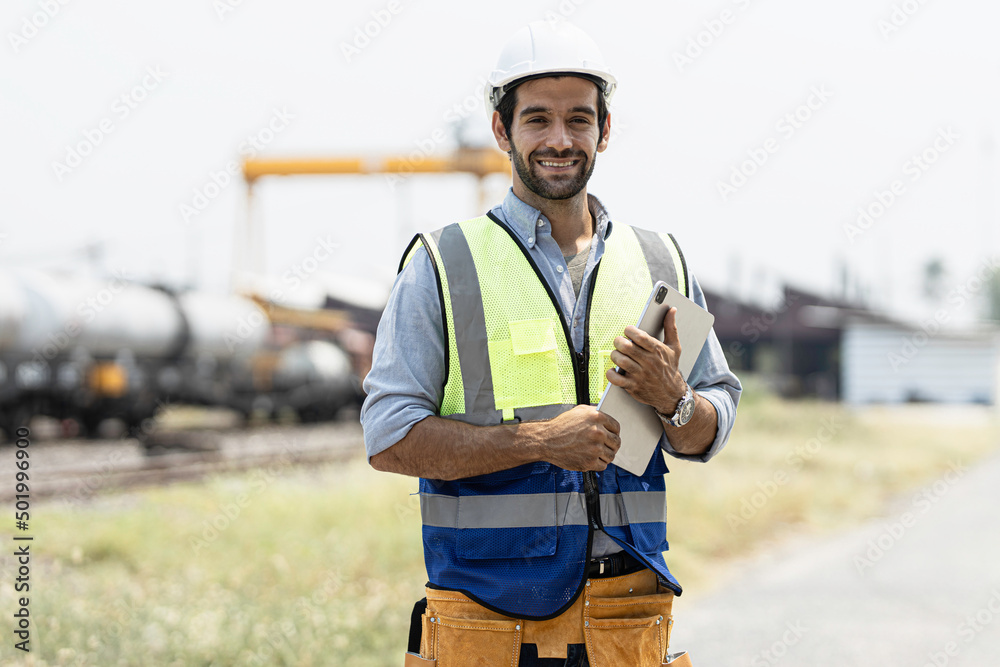A handsome engineer happily posing portraits at the train station. A handsome engineer happily posing portraits at the train station.