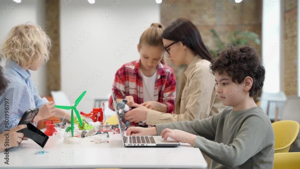 Cute little girl learn programming toys in STEM class together with young female teacher Cute little girl learn programming toys in STEM class together with young female teacher