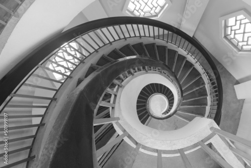 Spiral staircase resembling a fibonacci spiral with high contrast black, white, and gray shades