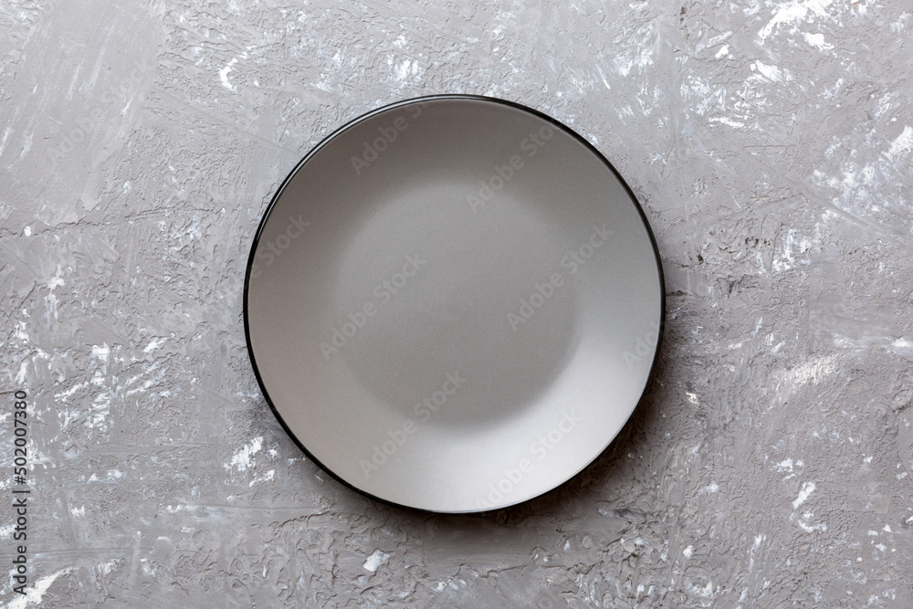 Top view of empty grey plate on cement background. Empty space for your ...