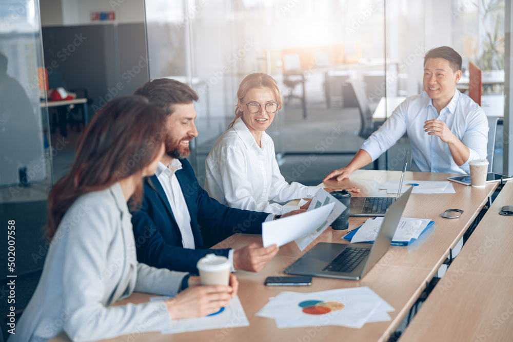 Confident and successful team. Group of people are working together in office. Blurred background Confident and successful team. Group of people are working together in office. Blurred background