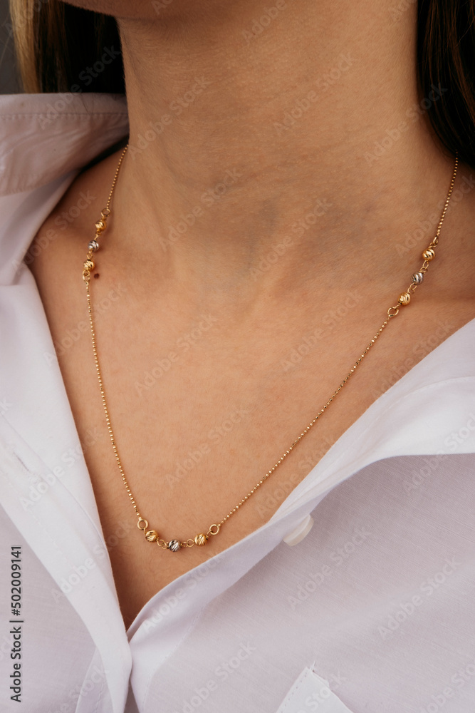 Close-up young woman wearing gold chain necklace. Modern fashion details. minimalist lifestyle Close-up young woman wearing gold chain necklace. Modern fashion details. minimalist lifestyle