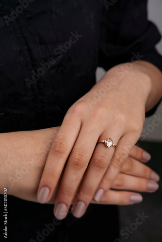 Golden Ring on a female hand, diamonds Diamond ring in hands of young lady. Close-up photo shoot