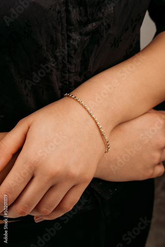 women s gold bracelet on the girl s hand  women s accessories  jewelry  gold bracelet with stones  women s jewelry  a girl with a bracelet on her arm  a bracelet with stones