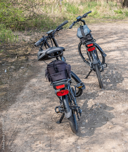 A pair of Wisper electric folding bikes with Altura luggage in the countryside