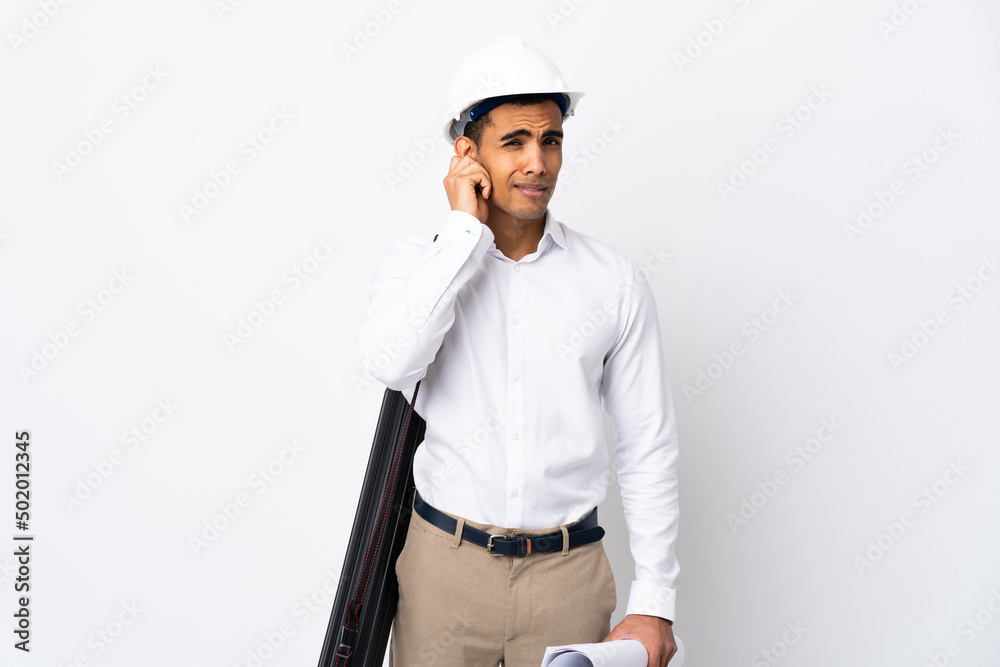 African American architect man with helmet and holding blueprints over isolated white background _ frustrated and covering ears African American architect man with helmet and holding blueprints over isolated white background _ frustrated and covering ears