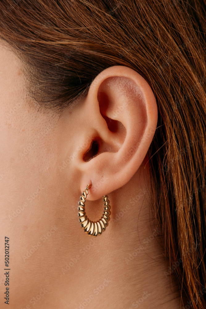 Jewelry, earrings in a beautiful girl's ear, women's accessories, gold earrings, earrings with stones, special diamonds