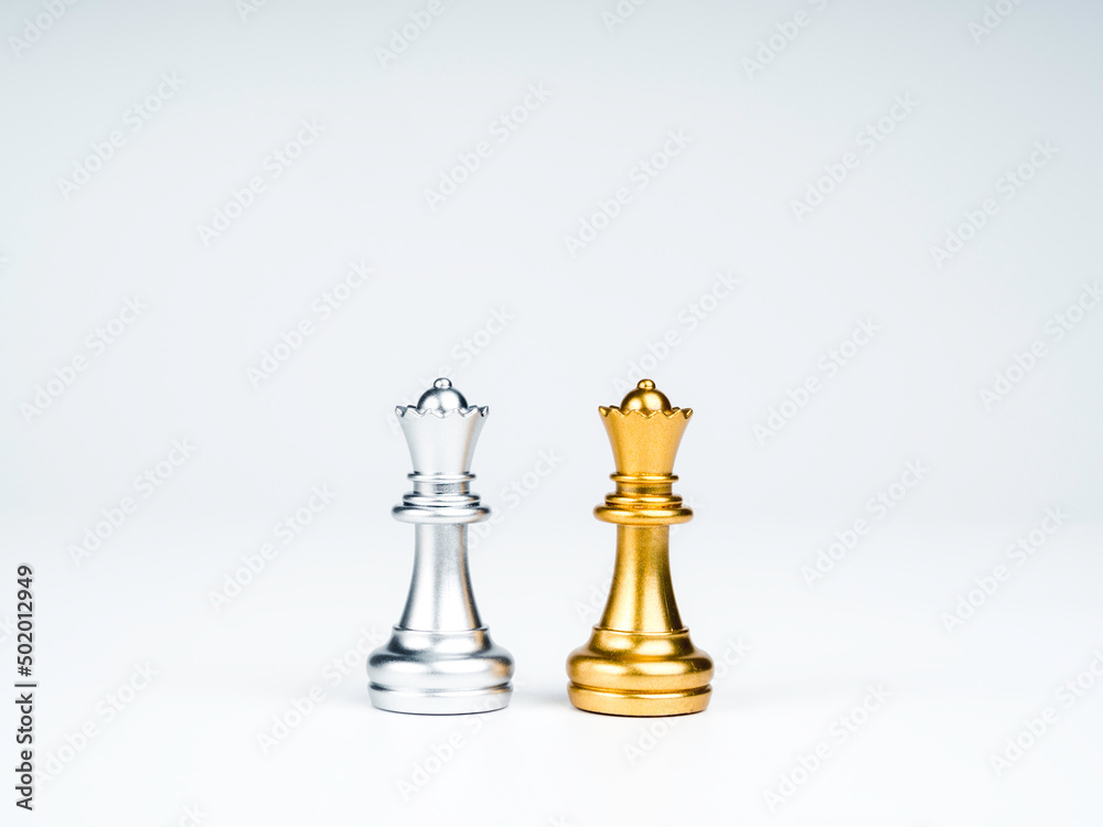 A golden queen chess piece and a silver queen chess piece are standing together isolated on white background. Leadership, partnership, competitor, confrontation, and business strategy concept.
