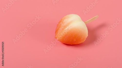 angle view beauty peach shape popsicle melting on pink timelapse