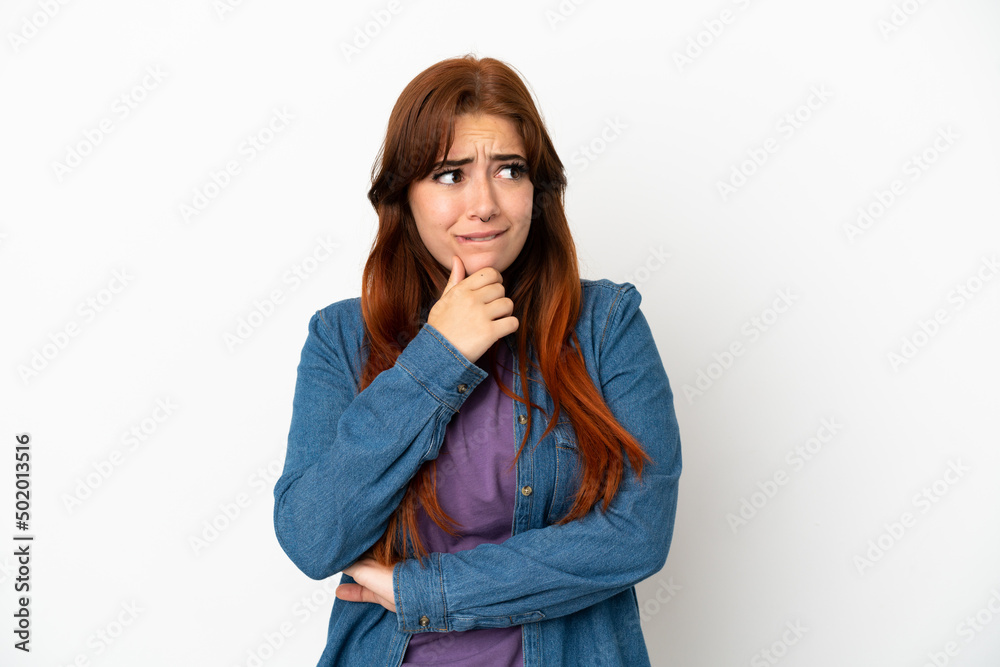 Young redhead woman isolated on white background having doubts and thinking Young redhead woman isolated on white background having doubts and thinking